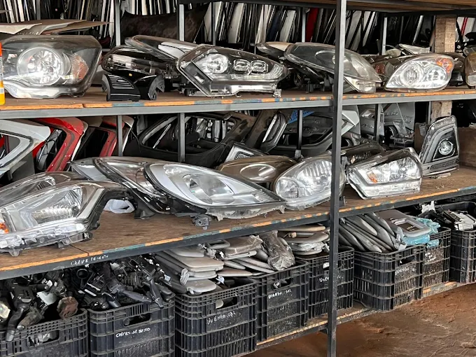 Prateleiras com faróis e lanternas automotivas usadas